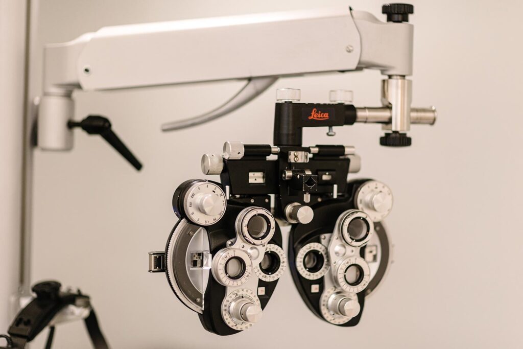 Leica phoropter used for eye exams, with multiple dials and lenses mounted on an arm.