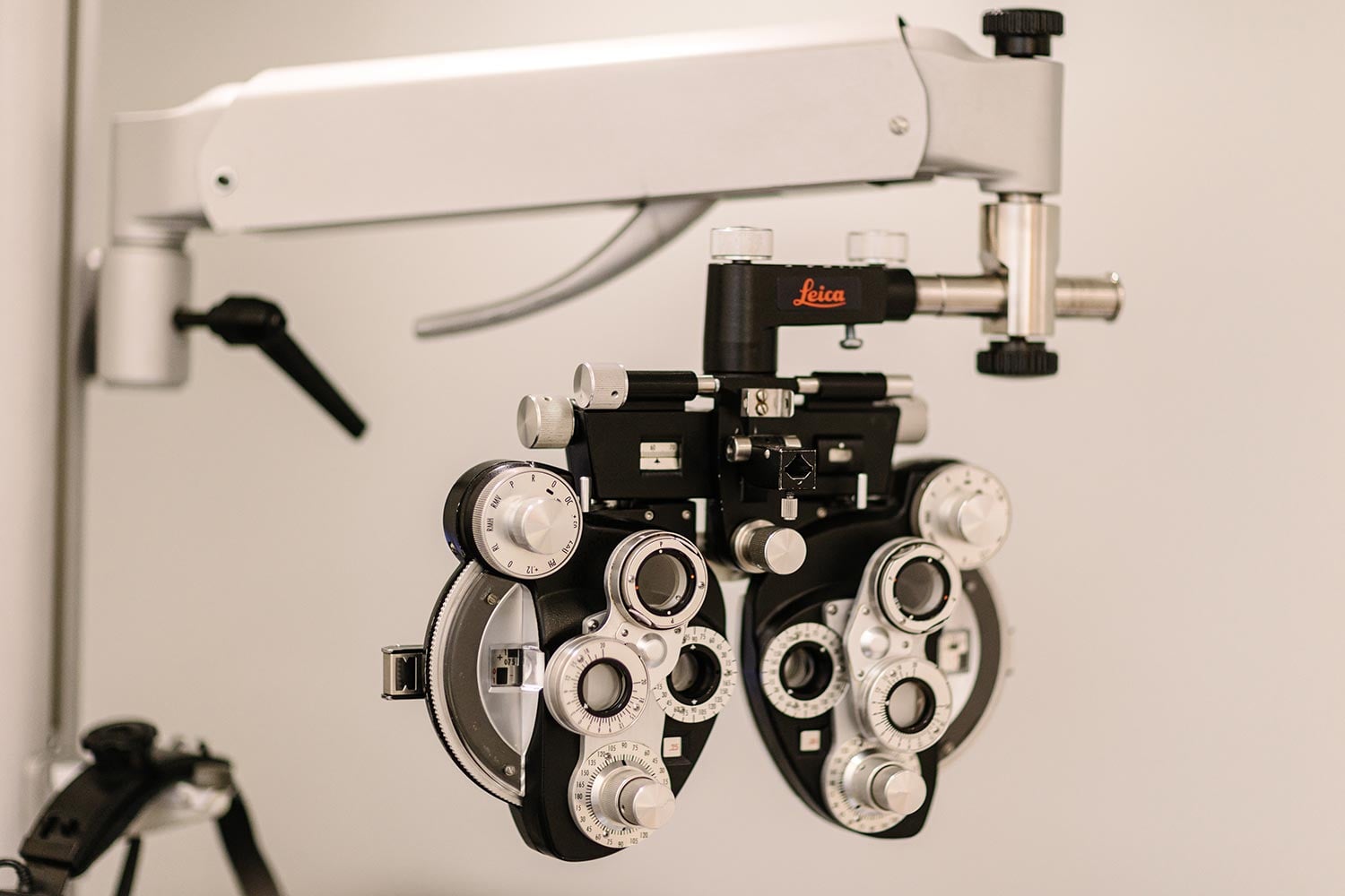 Leica phoropter used for eye exams, with multiple dials and lenses mounted on an arm.