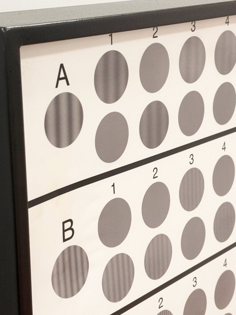 Close-up of a grid/chart with gray circular markers in rows A and B and columns 1–4 on a display panel.