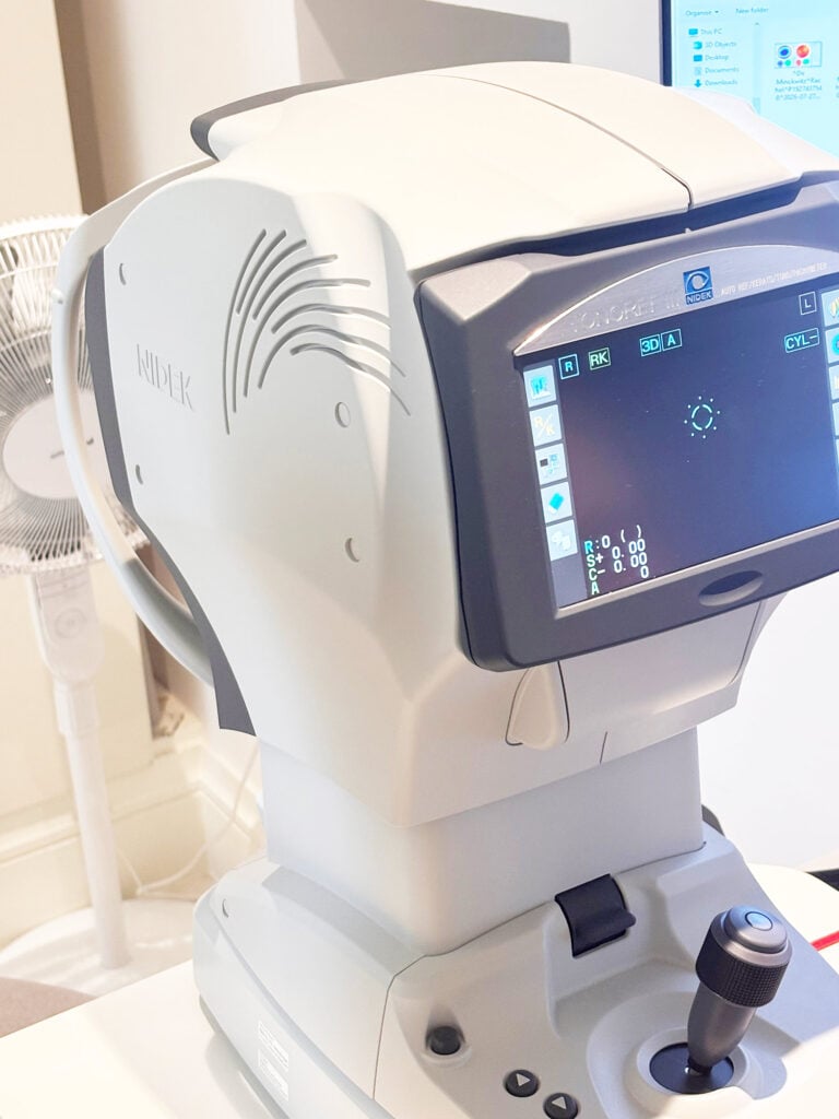 Ophthalmic diagnostic machine (autorefractor/keratometer) with joystick and touchscreen for eye measurements, labeled NIDEK.